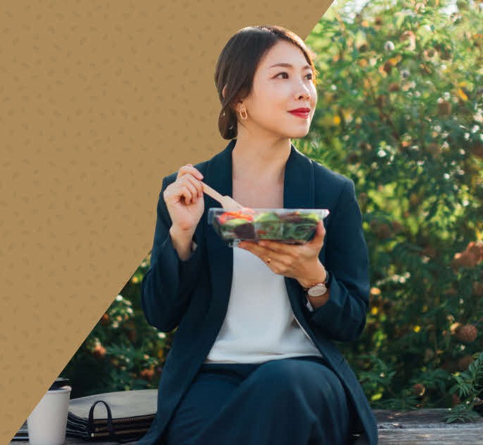 Woman enjoying her customised grain bowl, which symbolises the combination of investments and insurance.